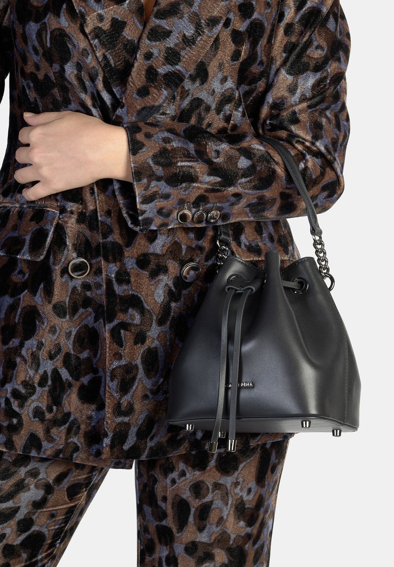 Borsa a secchiello in pelle nera con texture liscia, chiusura con coulisse e manico a catena; impreziosita da finiture in argento e piedini protettivi.