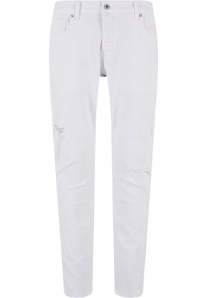 Biele džíny s úzkym strihom, ktoré majú opotrebované detaily na kolenách, päť vreciek, pútka na opasok a kovové zapínanie na gombík.