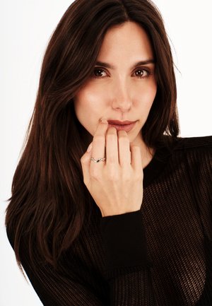 Hopeasiru, joka on sormessa, jolla on vaalea iho, mustan neulotun yläosan sisällä, jossa on teksturoitu kangas. Sormuksessa on joustava, orgaaninen muotoilu.