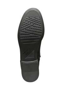 Suela de zapato negra con un diseño texturizado, patrón en zigzag y agujeros de drenaje. Marca Geox visible. El material parece goma.