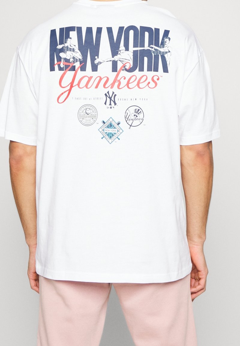Biała koszulka bawełniana z grafiką 'NEW YORK Yankees' w granatowym i czerwonym kolorze, z wieloma logo na plecach w różnych odcieniach kolorystycznych.