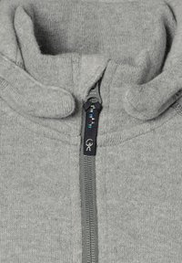 Grå fleecejakke med lynlås, blød tekstur, høj krave og kontrasterende lynlåsdetalje med en dekorativ trækstrop og logo.