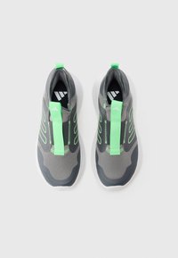 Γκρι αθλητικά παπούτσια με πράσινες λεπτομέρειες και σχεδιασμό που μοιάζει με κάλτσα. Διαθέτουν υφασμάτινο επάνω μέρος με υφή, θηλιά για τράβηγμα και ελαφριά σόλα.