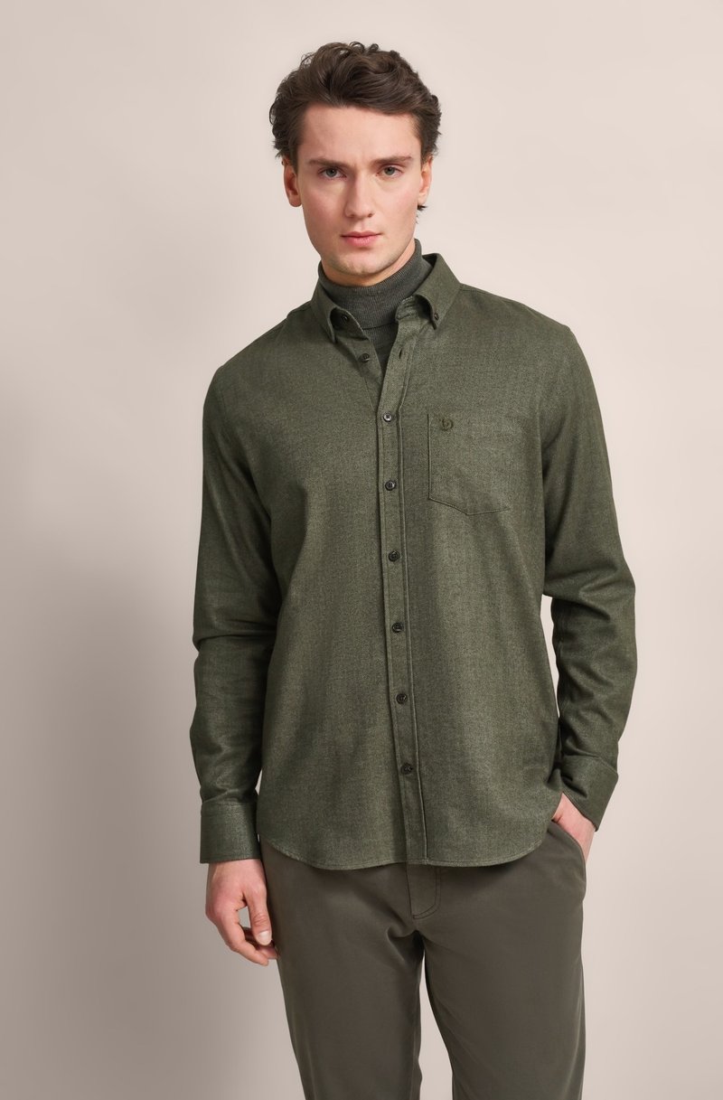 Green flannel shirt with button closure, single chest pocket, and long sleeves. Worn with a gray turtleneck and olive pants.
