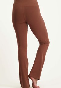 Braune, enganliegende Yogahosen mit ausgestelltem Design, aus weichem, dehnbaren Stoff. Mit hohem Bund und glatter Textur.