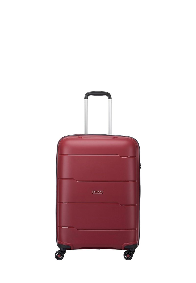 Maleta roja rígida con surcos horizontales, acentos negros, asa retráctil y cuatro ruedas para movilidad. Diseño compacto y textura suave.
