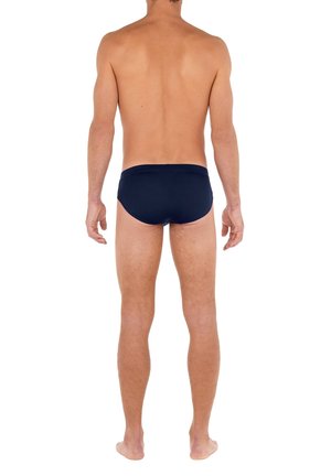 Dunkelblaue Schwimmbriefe mit einem weichen elastischen Bund. Glatte Textur, minimale Abdeckung und ein enganliegendes Design, von hinten betrachtet.