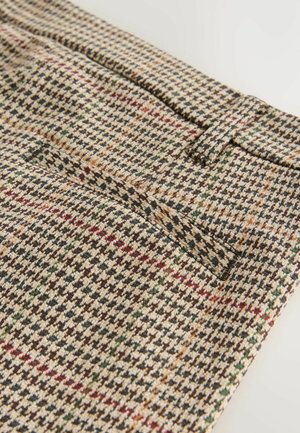 Bruin houndstooth patroon stof met rode en groene accenten; heeft een gladde textuur en een enkele zak aan de voorkant.