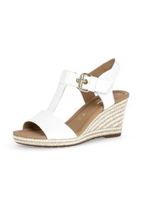Bílé wedges sandály s textilním svrškem a texturovanou espadrilkovou podrážkou. Vyznačují se designem T-popruhu a zlatou sponou.