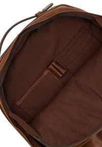 Hnědá kožená taška uvnitř s hladkou texturou, s tmavě hnědou látkovou podšívkou, sloty na karty a zipovým uzávěrem.