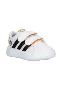 Sneaker bianche con strisce nere, due cinturini in velcro, accentuazione arancione sul tallone e un logo colorato sulla linguetta. Suola in gomma.