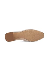 Suela de un zapato plano beige con tacón de goma texturizado y agarre estampado en la zona de los dedos, mostrado sobre un fondo blanco.