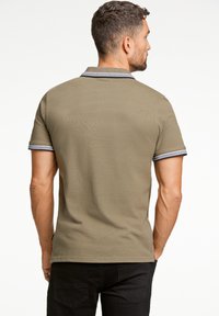 Olijfgroen polo shirt met een contrasterende zwart-wit gestreepte kraag; korte mouwen; gemaakt van ademend materiaal met een gladde textuur.
