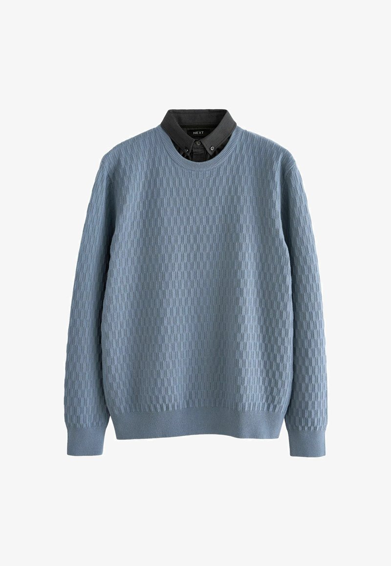 Hellblauer Strickpullover mit einem strukturierten Karomuster, Rundhalsausschnitt und gerippten Bündchen. Über einem dunklen Hemd mit Kragen geschichtet.