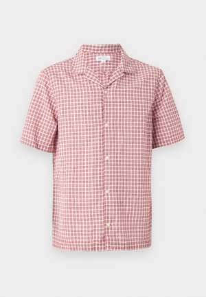 Chemise à manches courtes boutonnée avec motif à carreaux rouges et blancs et col classique sur un fond uni.