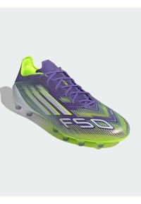 Paarse en neon groene voetbalschoenen met een gestructureerd oppervlak, voorzien van opvallende lijnen en een lichte constructie. Accentueerde logo aan de zijkant.
