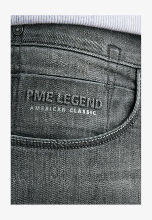 Grijze denim jeans met een textuurafwerking, voorzien van een achterzakaccent en een reliëflogo met de tekst "PME LEGEND AMERICAN CLASSIC."