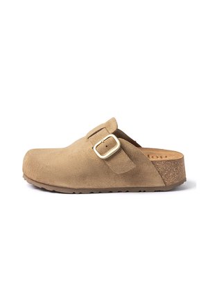 Beige suede slip-on clog with adjustable gold buckle strap and cork sole, flat rubber outsole, designed for comfort and casual wear.