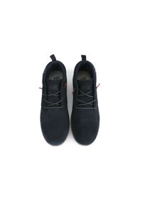 Scarpe in suede nero con punta arrotondata, dotate di lacci neri, sottili accenti rossi e una linguetta sul tallone. Texture morbida e design minimal.