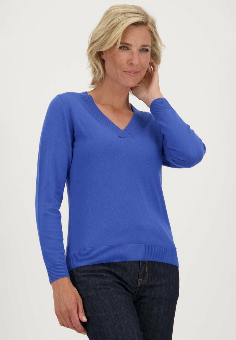 Blauwe V-hals trui met lange mouwen, geribbelde mouw- en tailleboorden. Zachte textuur, slimfit ontwerp. Gemaakt met donkere denim jeans.