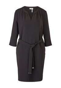 Robe noire longueur genou avec manches trois-quarts, encolure décroisée, détails froncés et ceinture à nouer à la taille.