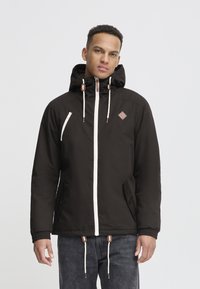 Black jacket with a hood, featuring a white zipper, side pockets, and brown accents. The material appears smooth with a slightly textured finish.