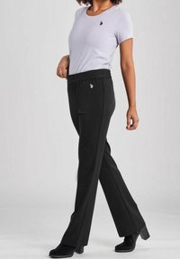 Svarta elastiska midjebandsbyxor med rak ben-design. I kombination med en ljuslila kortärmad tröja med en liten logotyp.