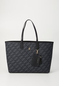 Navy patterned tote bag with black leather accents, two handles, and a detachable cardholder attached by a gold hardware clip.