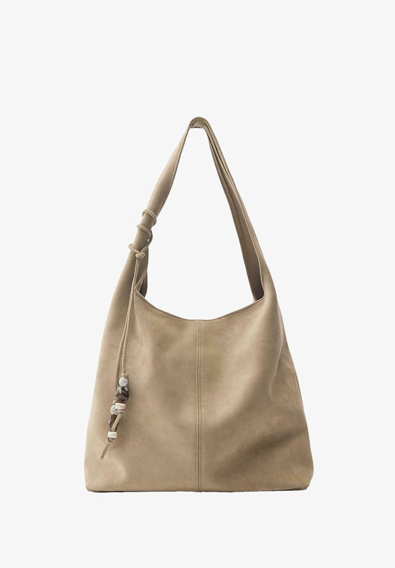 Beżowa zamszowa torba na ramię z pojedynczym paskiem i ozdobnymi koralikami zawieszonymi na sznurku po bokach.