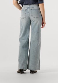 Lichtblauwe wijde spijkerbroek van denim, met een hoge taille, twee achterzakken en een onafgewerkte zoom bij de enkel.