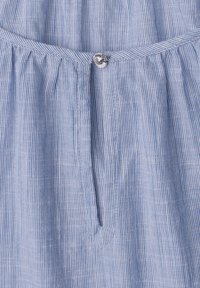 Tissu rayé vertical bleu clair et blanc avec une couture froncée et un petit bouton décoratif rond au centre.