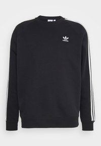 Svart Adidas sweatshirt med vita tre ränder på ärmarna och vit trefoil-logotyp på bröstet, rundad halsringning och långa ärmar.