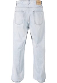 Svetlo modri denim jeans s sproščenim fitom, ki vključujejo dve zadnji žepu, naravnost hlačnico in usnjeno oznako na pasu.