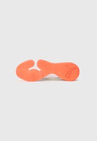 Weiße Sneaker-Sohle mit einer strukturierten orangen Zwischensohle und einem markanten Logo. Geschwungene Form mit komplexem Muster für besseren Halt.