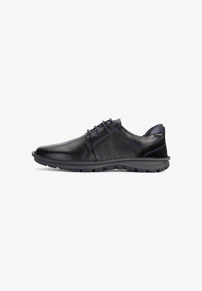 Chaussure décontractée pour homme en cuir noir avec des surpiqûres bleu foncé, fermeture à lacets et semelle en caoutchouc texturée sur fond blanc.