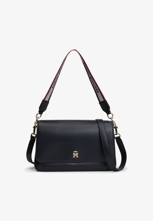 Zwarte leren schoudertas met goudkleurige sluiting, twee verstelbare riemen waaronder een stoffen riem met patroon en rode randen.