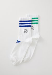 Garu garuma zeķes baltā kokvilnā ar zilām un zaļām svītrām augšpusē. Iekļauts melns futbola emblēma un zils logo. 