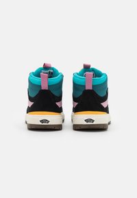 Zapatillas altas que combinan diferentes materiales en negro, verde azulado y rosa, con un upper texturizado, un cuello acolchado y un logotipo en la suela.