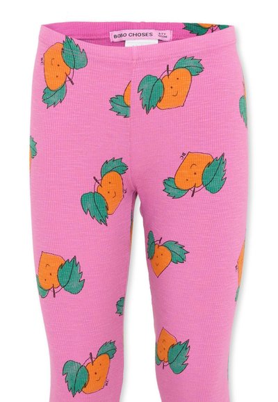 Leggings roses côtelés avec un motif répétitif de cœurs orange souriants avec des feuilles vertes et une étiquette "Bobo Choses" à la taille.