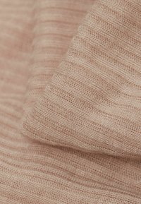 Jasnoróżowa tkana tkanina, charakteryzująca się miękką strukturą z delikatnymi poziomymi paskami i nieco luźnym splotem, co tworzy przewiewny wygląd.