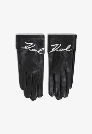Mănuși din piele neagră cu o textură netedă, având un logo alb, scris în stil de mână, "Karl" pe mansetă și detalii cusute pe degete.