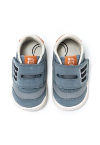 Zapatos de tela azules con correas de Velcro, suelas blancas y acentos naranjas. Cuentan con una textura suave y un logo en el lado.