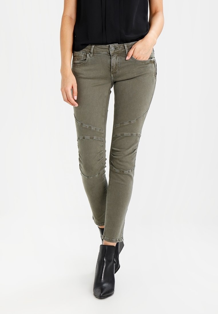 Olivově zelené džíny s úzkým střihem, s texturovanými detaily a švy. Doplněno černými kotníkovými botami.