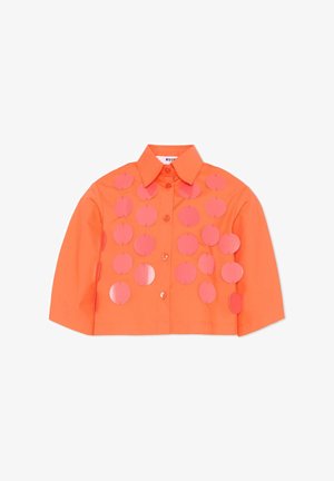 Chemise courte orange avec boutons à l'avant et rangées de sequins circulaires roses brillants sur le devant et les manches, répartis uniformément en lignes verticales.