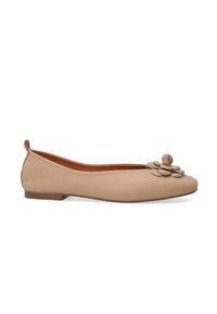 Beige Leder Ballerina mit runder Zehenform, versehen mit einem dekorativen Blumenakzent und einer niedrigen braunen Sohle. Glatte Textur mit minimalistischem Design.