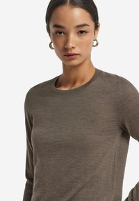 Brązowa koszula z długim rękawem, wykonana z miękkiego materiału, z okrągłym dekoltem. Charakteryzuje się gładką fakturą i dopasowanym krojem.