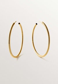 Pendientes de aro dorados con un diseño en espiral, que presentan una ligera textura y un acabado suave. Son circulares con extremos abiertos.