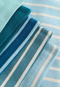 Échantillons de tissu soigneusement pliés dans différentes nuances de bleu avec des rayures blanches horizontales, disposés sur un fond rayé bleu clair.