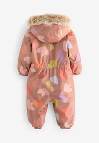 Tuta da neve rosa resistente all'acqua con cappuccio foderato in pelliccia ecologica. Forma astratta multicolore decora il tessuto. Polsini ed elastico in vita.