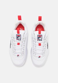 Baskets de sport blanches avec des accents rouges et navy, dotées d'un dessus texturé, d'un bout rond, d'un lacet et de languettes de talon renforcées.